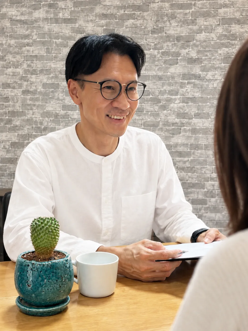 木のテーブルで穏やかに話を聞くARCHのスタッフ